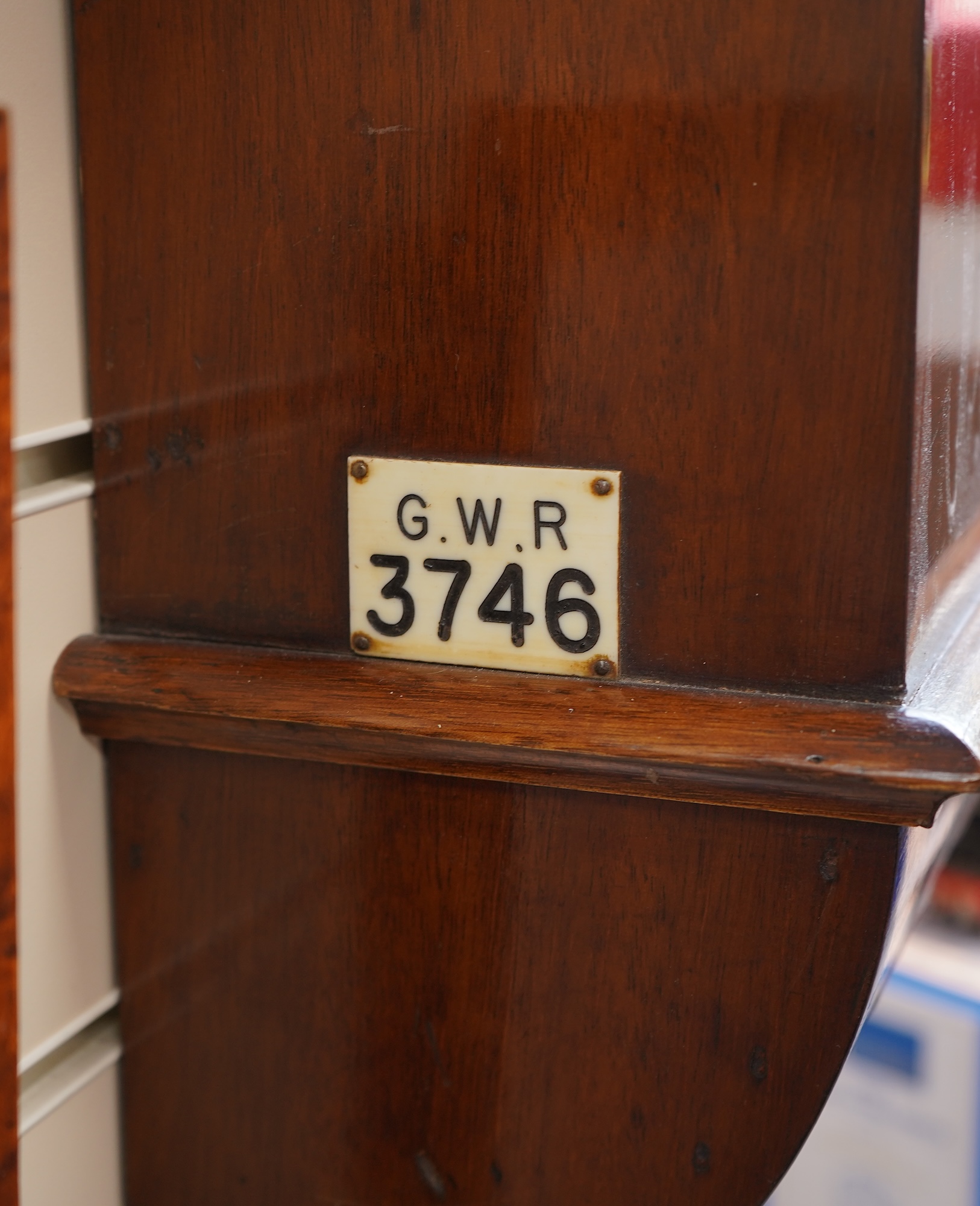 A GWR drop dial railway wall timepiece with fusee movement in a mahogany case, painted 12” dial with ‘shirt button’ GWR monogram and an ivorine plaque pinned to the lower left side of the case engraved with ‘GWR 3746’